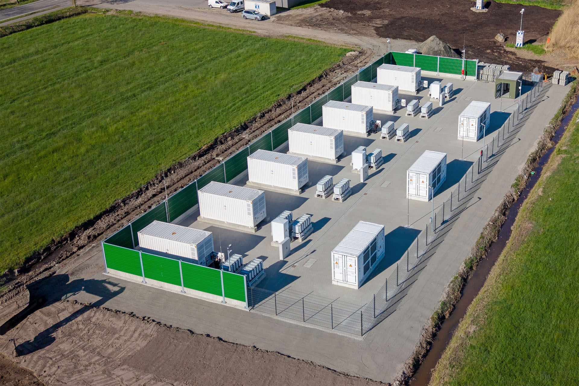 Luchtfoto van een batterijopslagpark met containerinstallaties en omheining.