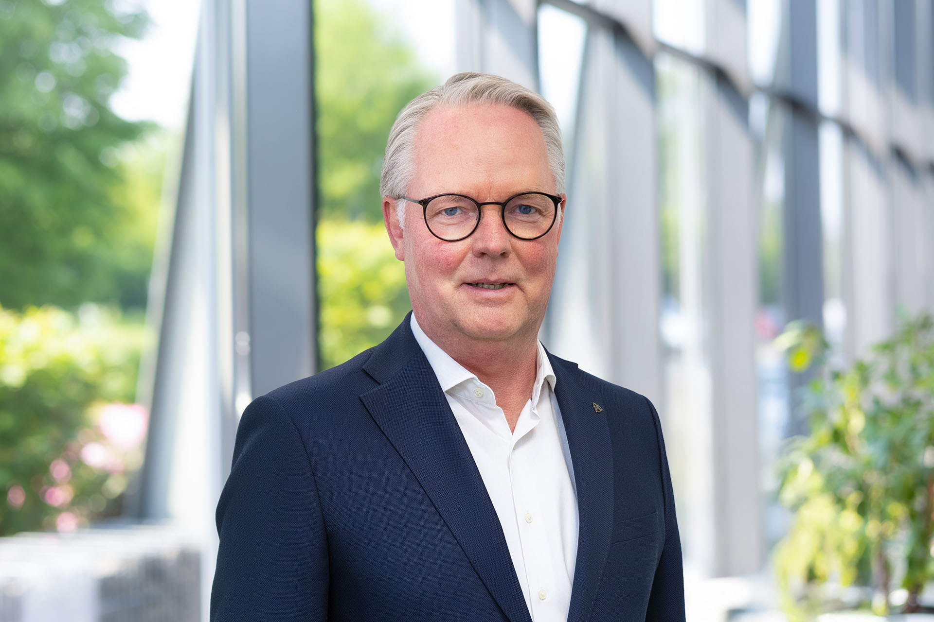 CFO Jürgen Deters in de ontvangsthal voor een glazen gevel.